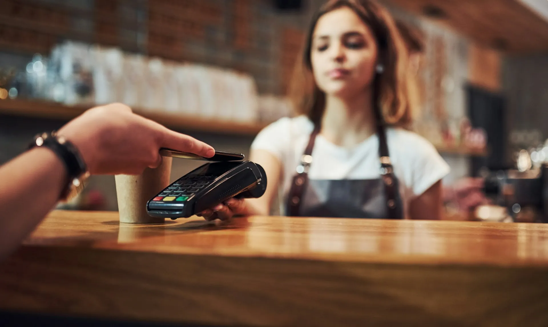 A customer buys a coffee with their smartphone