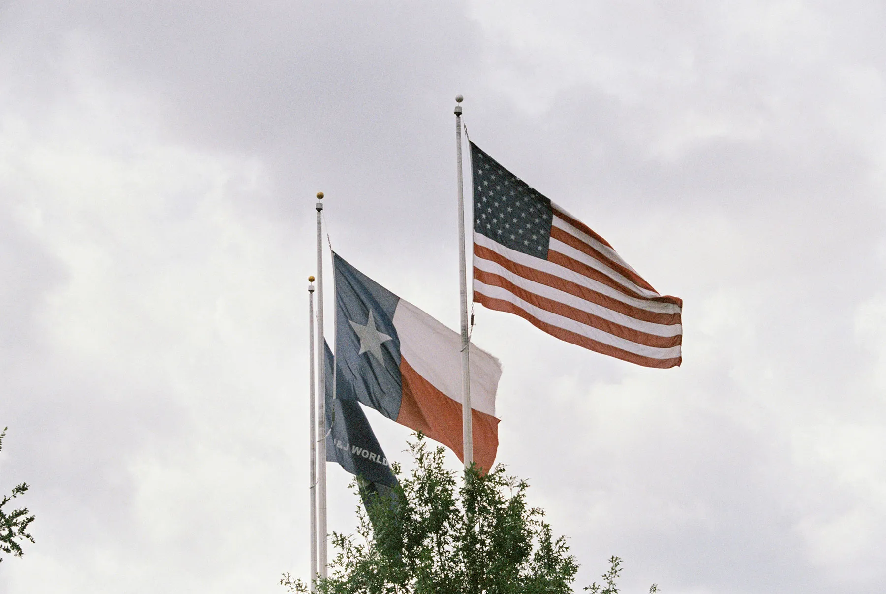 A United States flag and a Texas flag waving in the wind