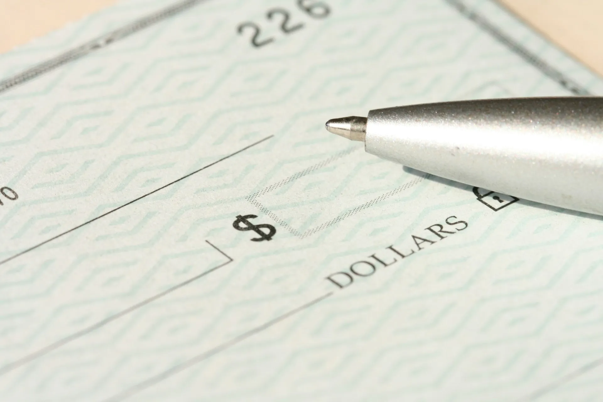 A closeup of a check and a pen