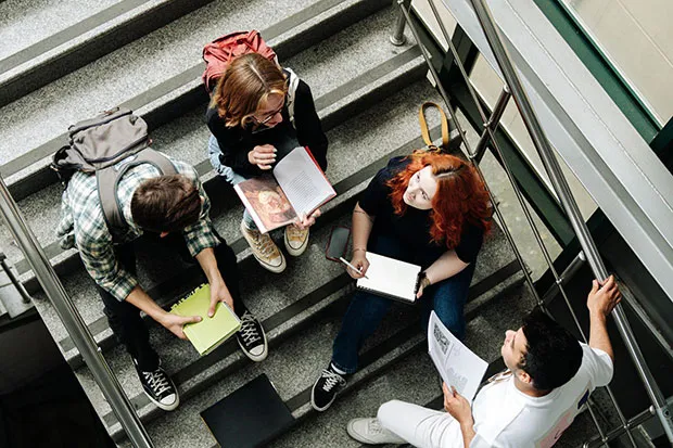Four college students studying in a stairwell