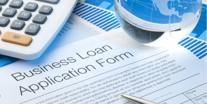 A closeup of a loan application and calculator