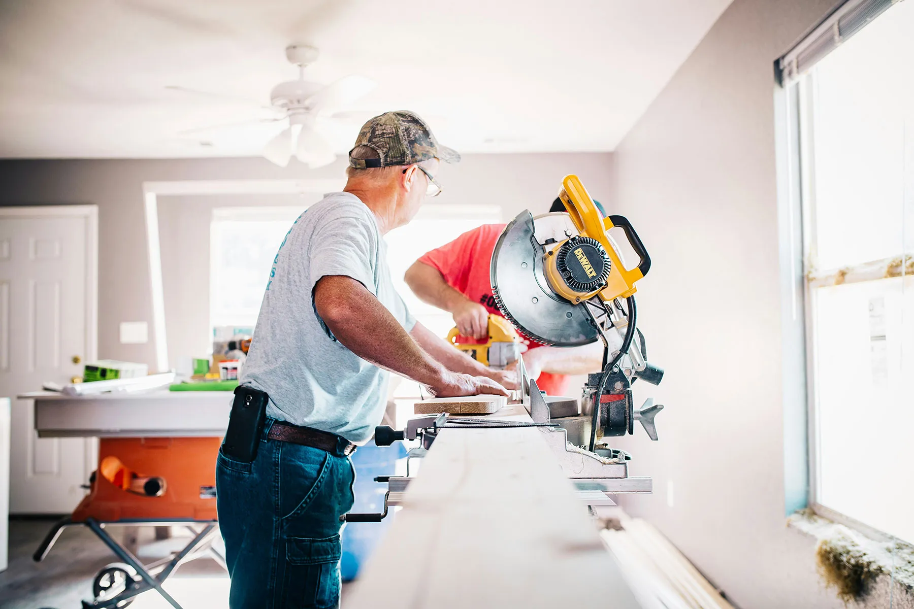 Two men working with a chop saw